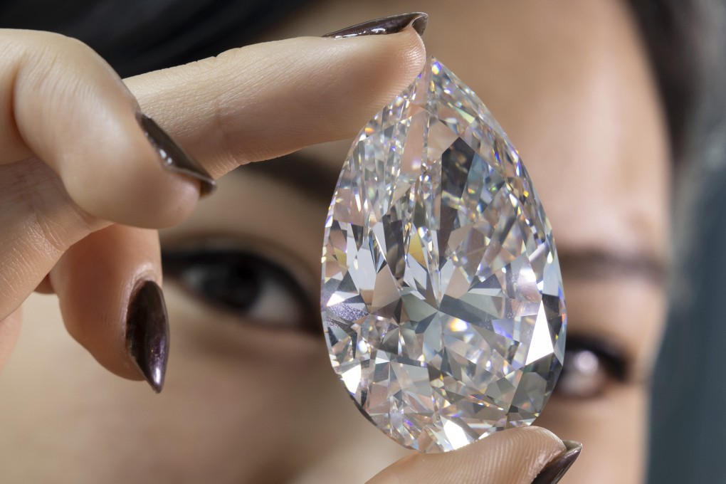 A Christie’s employee holds The Rock, the largest white diamond ever seen throughout auction market history, in Geneva, Switzerland on May 6. Photo: Keystone via AP