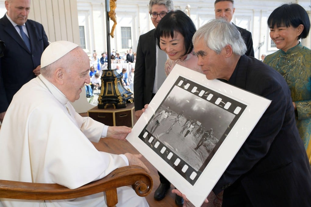 Photographer Nick Ut shows to Pope Francis his 1972 picture “The Terror of War”, also known as the “Napalm Girl”, next to Kim Phuc Phan Thi, featured in the picture as a child, during the weekly general audience at the Vatican on Wednesday. Photo: Vatican media via Reuters