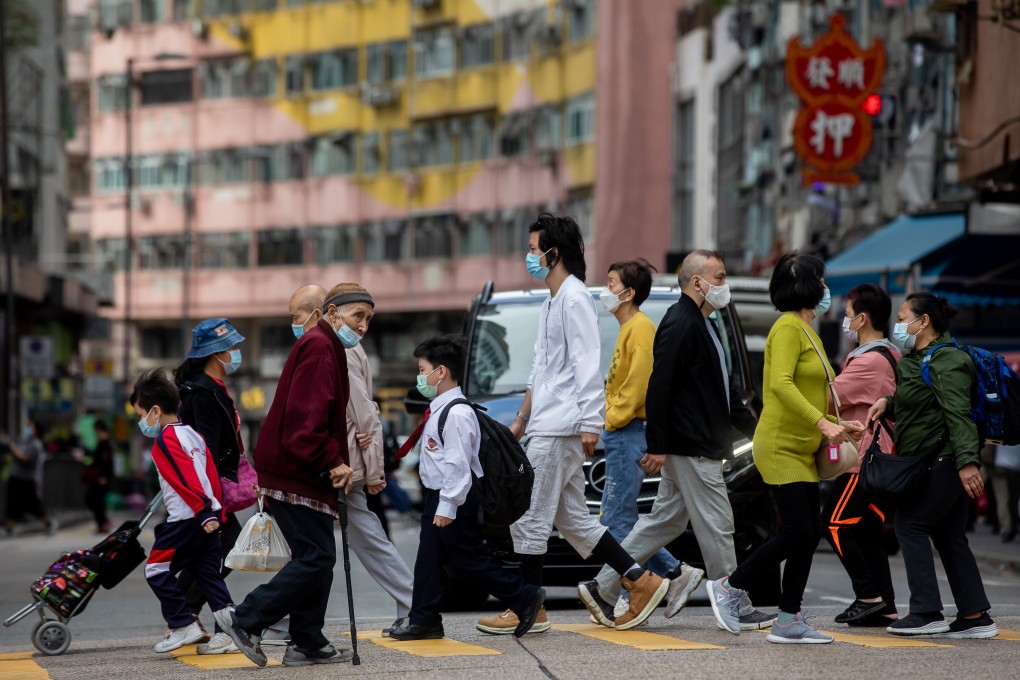 Pedestrians cross a road in Hong Kong on December 7, 2021. Enduring assumptions about the city’s population growth are now moot. Photo: Bloomberg
