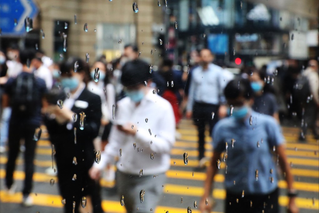 Office workers are seen through a window as they cross a road in Central. Photo: Nora Tam