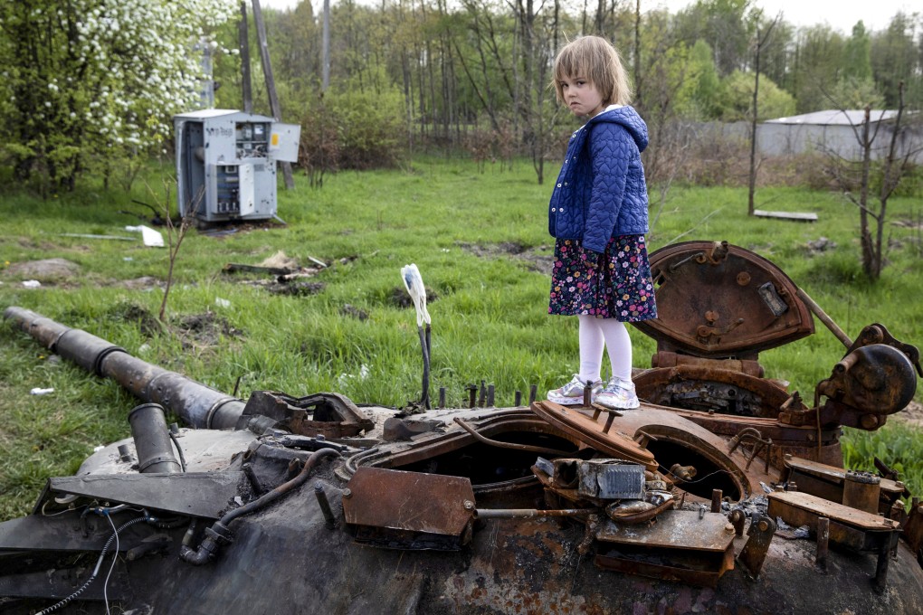 A child stands on a destroyed Russian tank near Makariv in Ukraine’s Kyiv region. Photo: Reuters