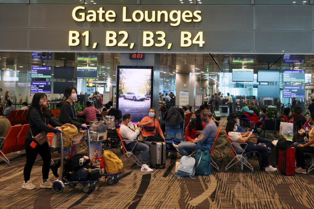 Travellers sit as they wait to embark at the Changi Airport in Singapore in March. Photo: Reuters