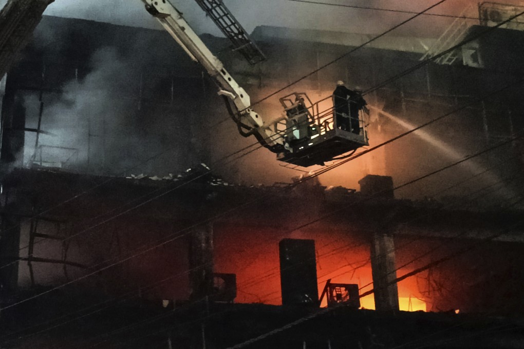 Fire officials try to douse a fire in a four storied building, in New Delhi, India. A massive fire erupted in a four-storied building in the Indian capital on Friday. Photo: AP