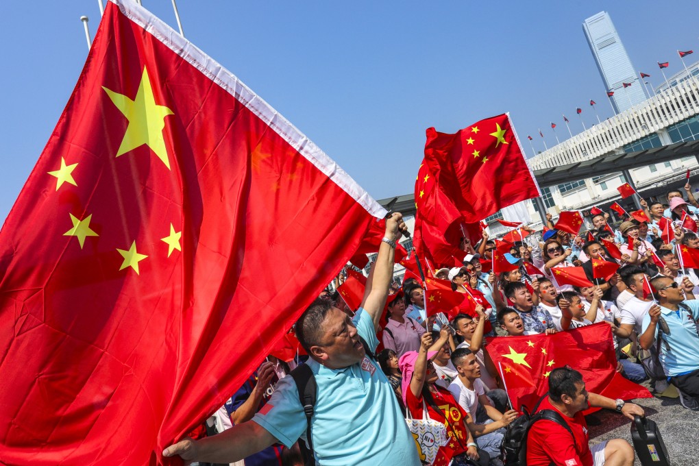 People wave the national flag at Star Ferry Pier in Tsim Sha Tsui on October 1, 2019. Photo: May Tse