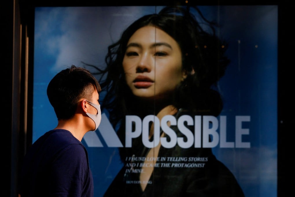 A masked man walks past an Adidas store in Hong Kong on April 14. Photo: Reuters