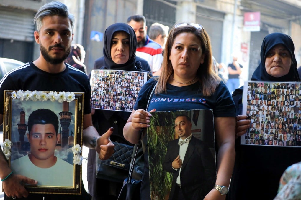 Families of victims of the 2020 Beirut port explosion carry portraits of their relatives outside a polling station in Beirut, Lebanon on May 15. Photo: AFP