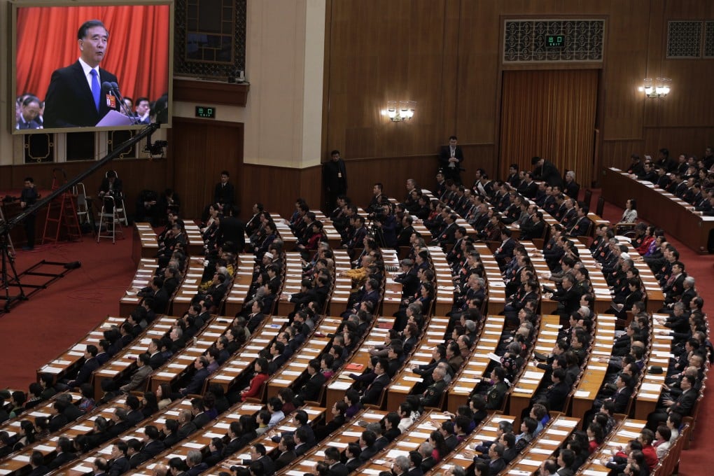 Chinese People’s Political Consultative Conference chairman and Politburo Standing Committee member Wang Yang appears on a screen to deliver a closing speech at a meeting on March 13, 2019. Photo: AP