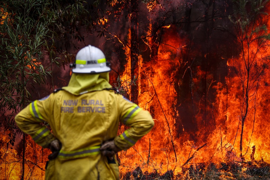 A New South Wales (NSW) Rural Fire Service volunteer watches a fire in bushland during back-burning operations in bushland near the town of Kulnura, New South Wales, Australia in December 2019. Photo: Bloomberg