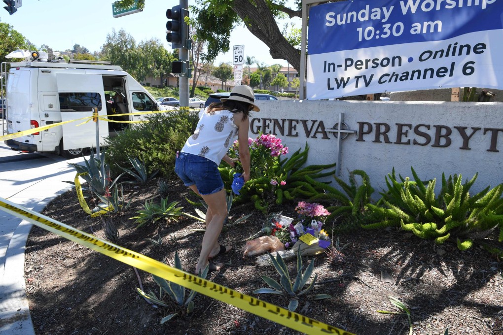A woman places flowers at a makeshift memorial outside the Geneva Presbyterian Church on Monday. One person was killed and five were wounded in a shooting at the church in Laguna Woods, California on Sunday. Photo: AFP