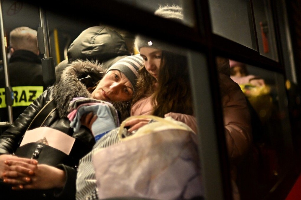 A mother and her child wait on a bus at the border in Medyka, Poland, to be taken to a safer place after crossing the border from Ukraine. Photo: TNS