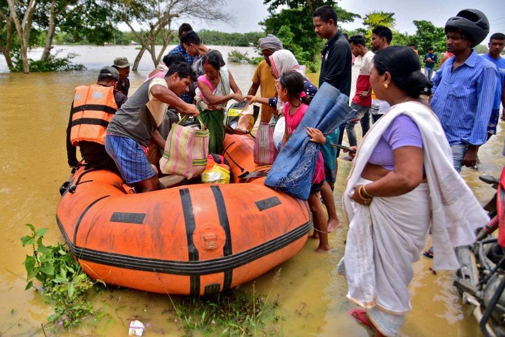 People disembark from a boat after being evacuated from a flooded village in Nagaon district in northeastern Assam state, India, on May 18. Photo: Reuters