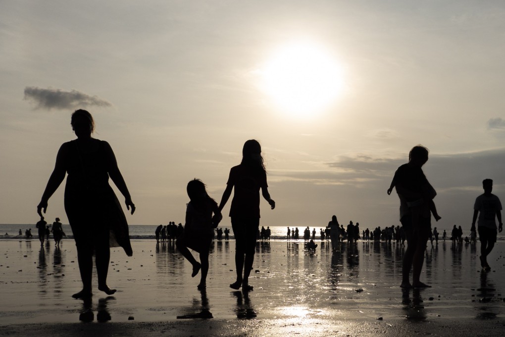 Tourists walk at a beach in Bali, Indonesia. Indonesia will no longer require a negative pre-departure test for foreign and domestic travellers. Photo: EPA-EFE