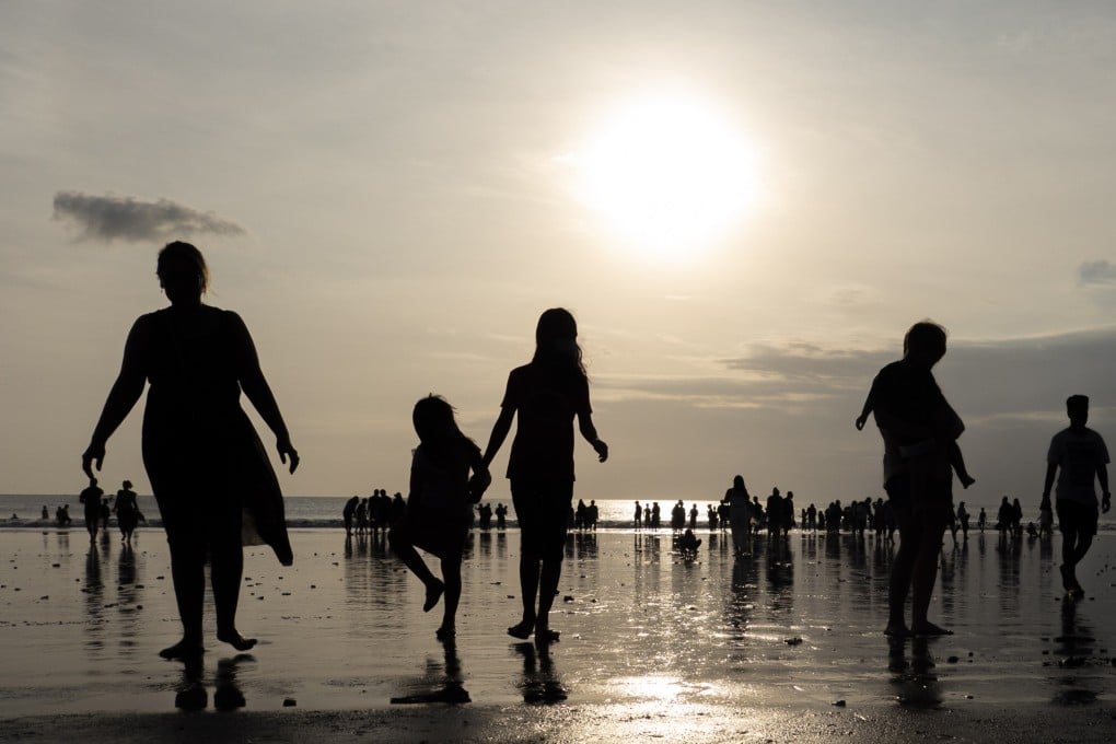 Tourists walk at a beach in Bali, Indonesia. Indonesia will no longer require a negative pre-departure test for foreign and domestic travellers. Photo: EPA-EFE