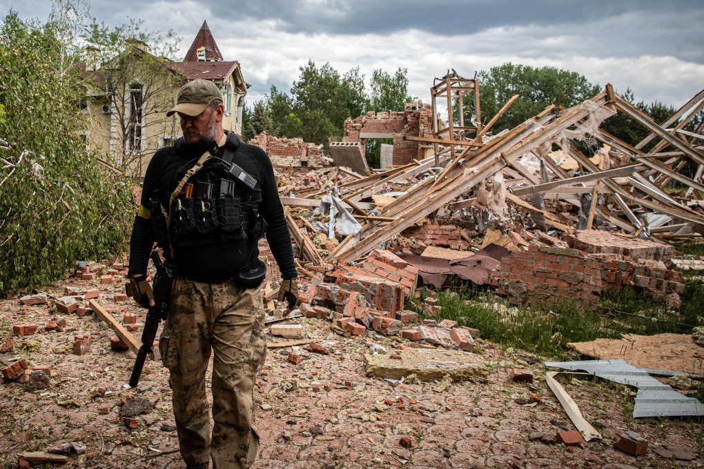 A Ukrainian territory defence soldier walks past the ruins of a building hit by shelling in the separatist region of Donbas. Photo: dpa
