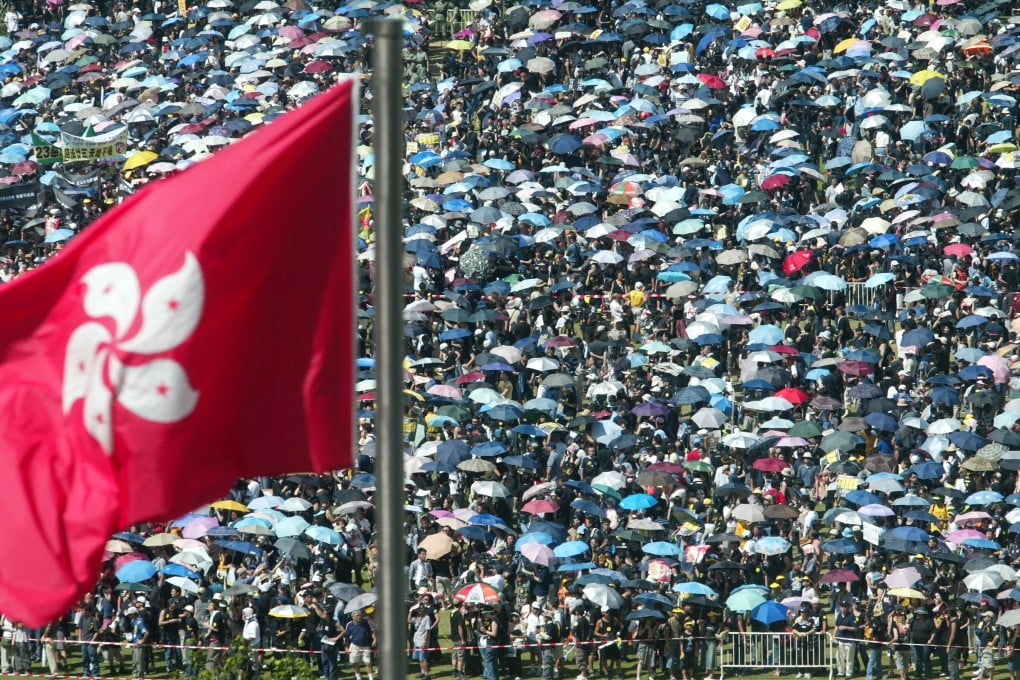 Protesters assemble in Victoria Park in the shadow of the Hong Kong flag. People were still arriving at the Central Government Offices at 9pm, six hours after the first marchers set out from Causeway Bay. Photo: Martin Chan