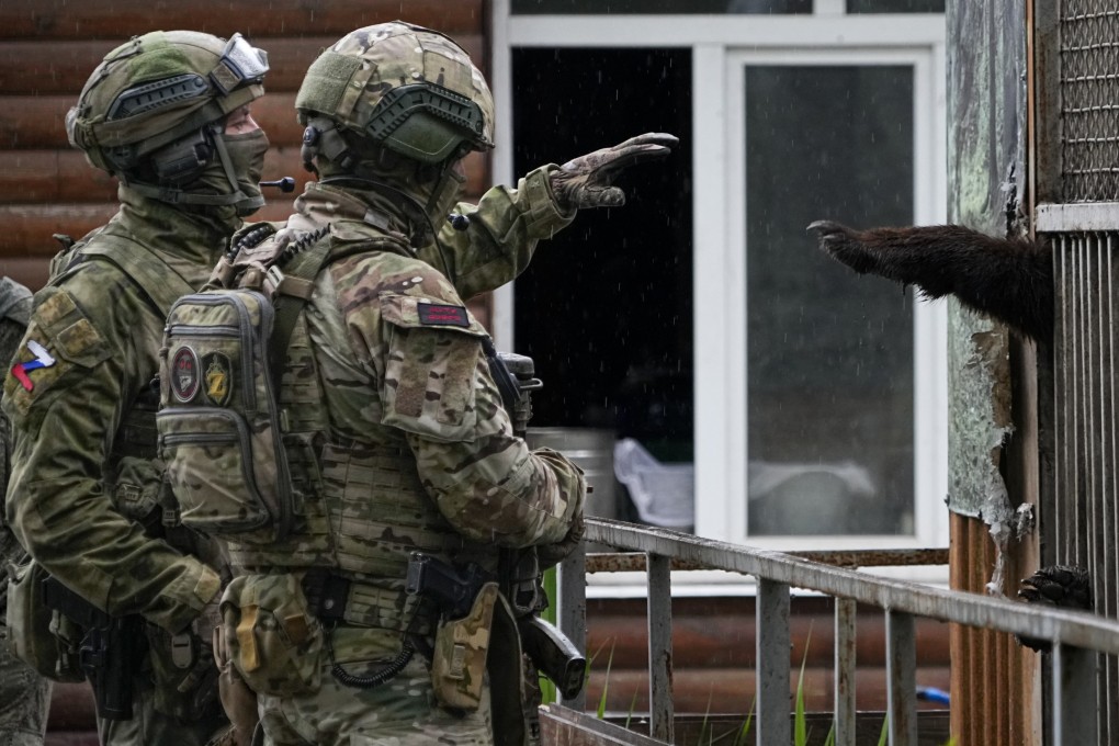 Russian soldiers play with a bear at the zoo in Mariupol, eastern Ukraine. Photo: AP