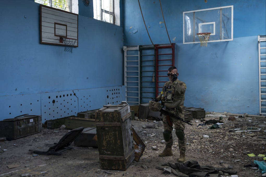 A Ukrainian serviceman inspects a school damaged in fighting with Russian troops in a village outside Kharkiv, in eastern Ukraine. Photo: AP