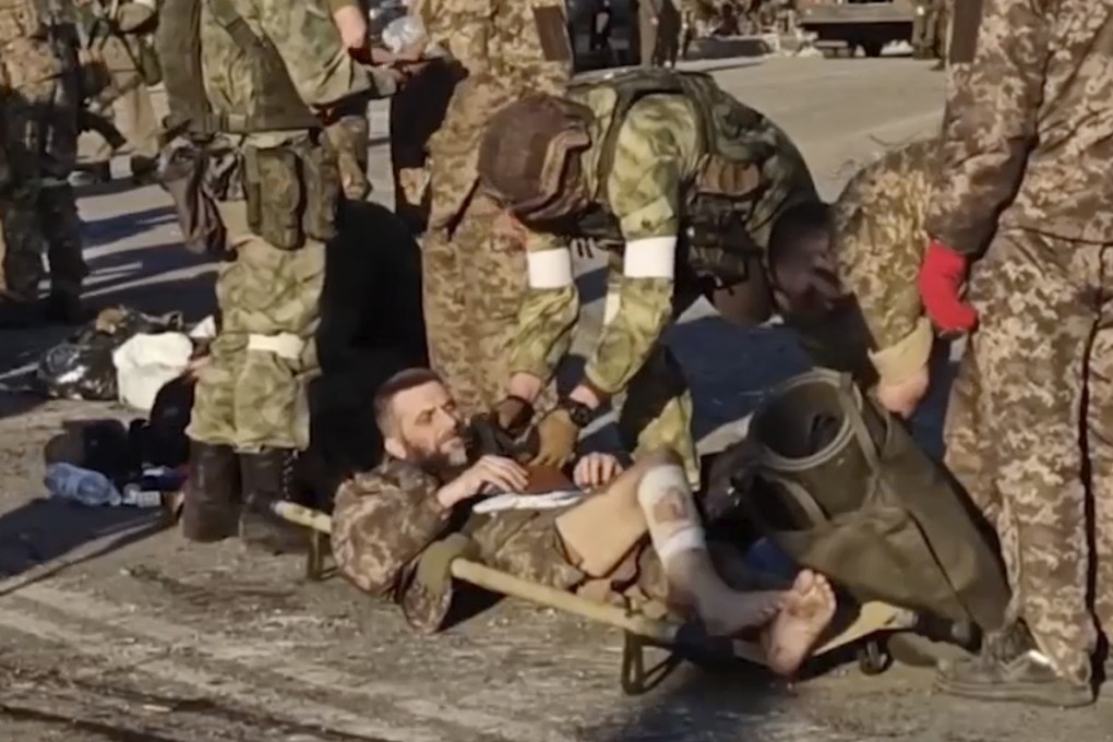 Russian servicemen frisk Ukrainian servicemen as they are being evacuated from the besieged Azovstal steel plant in Mariupol, Ukraine. Photo: Russian Defense Ministry Press Service via AP