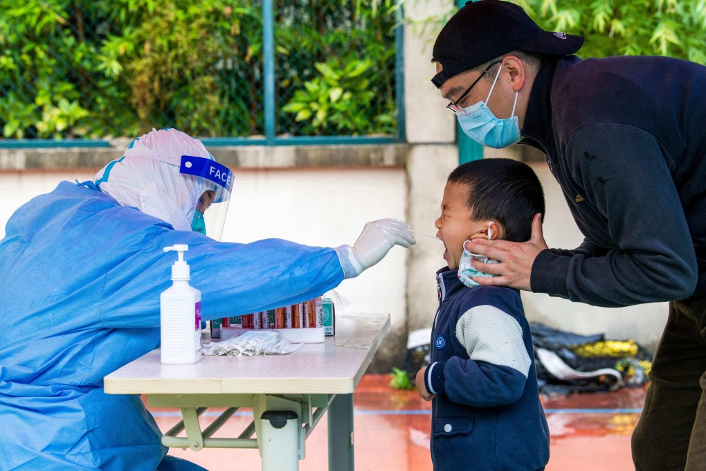 A health worker takes a swab sample from a child to be tested for Covid-19 in a compound under lockdown in the Pudong district of Shanghai on May 13, 2022. Photo: AFP