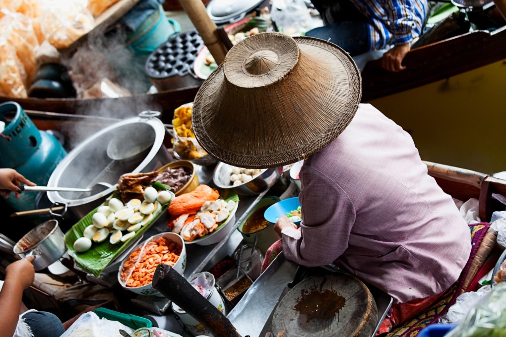 Asian Food vendor selling traditional Thai food from her boat at the Damnoen Saduak Floating Market near Bangkok. Photo: Getty Images