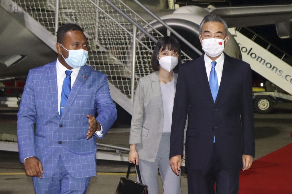 China’s Foreign Minister Wang Yi, center, is escorted from his plane on his arrival in Honiara, Solomon Islands, early on Thursday. His visit comes at the start of an eight-nation tour that comes amid growing concerns about Beijing’s military and financial ambitions in the South Pacific region. Photo: AP