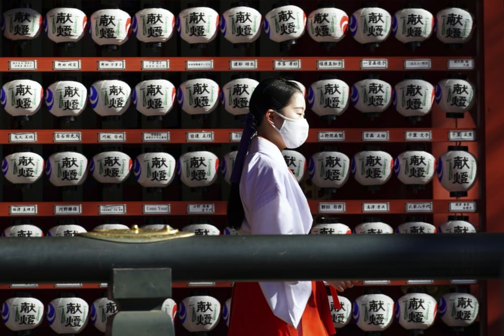 A shrine maiden walks at Kanda Myojin shrine Friday, Feb. 5, 2021, in Tokyo. (AP Photo/Eugene Hoshiko)