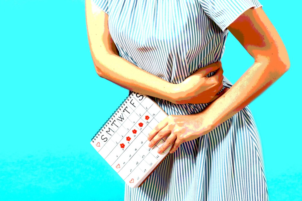 A woman in a blue dress holds a calendar to check her menstruation days. Photo: Shutterstock