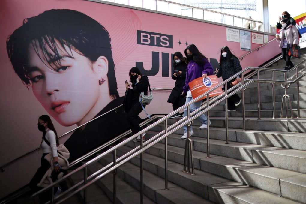 Fans of K-pop band BTS walk past an advertisement promoting their concert at Seoul Olympic stadium in Seoul, South Korea in March. Photo: Reuters
