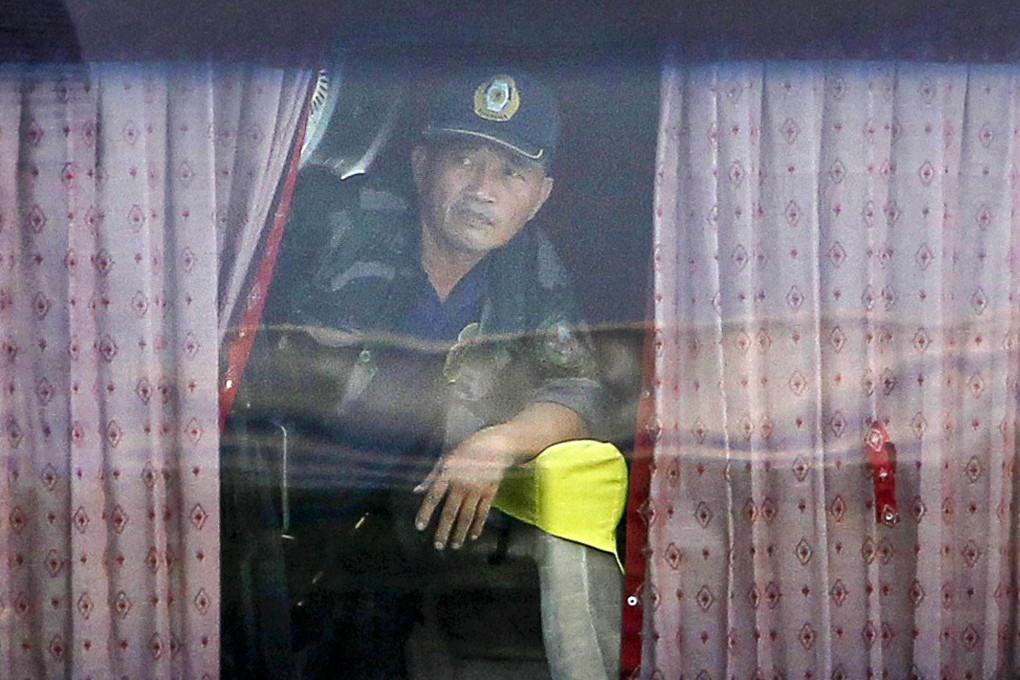 Gunman Rolando Mendoza, a former policeman, looks out of the bus. Photo: Reuters
