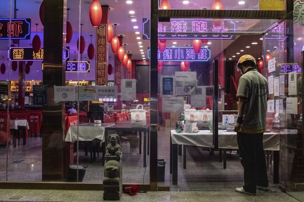A delivery worker waits for a dinner order at a restaurant offering only take-out services due to Covid-19 restrictions in Beijing, May 21, 2022. Photo: Bloomberg