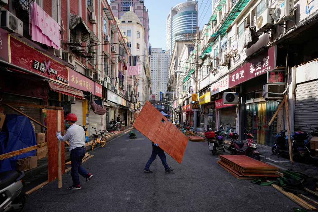 Workers dismantle barriers in a residential area of Shanghai on Tuesday, as the city prepares to end its two-month lockdown on June 1. Photo: Reuters