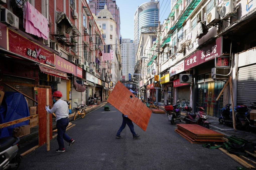 Workers dismantle barriers in a residential area of Shanghai on Tuesday, as the city prepares to end its two-month lockdown on June 1. Photo: Reuters