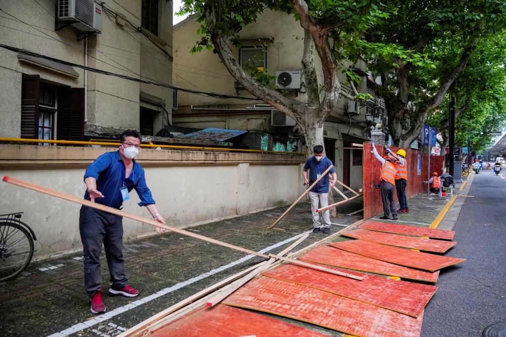 Workers dismantled barriers at a residential area during lockdown, amid the coronavirus disease (Ccovid-19) outbreak in Shanghai on May 30, 2022. Photo: Reuters