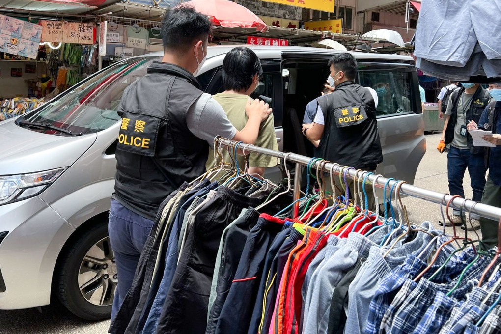 Police escorting the suspects from the pharmacy to a vehicle. Photo: Handout