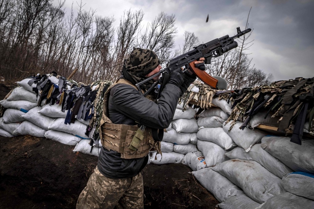 A Ukrainian serviceman shoots at a Russian drone with an assault rifle from a trench at the front line east of Kharkiv on March 31, 2022. Chinese military researchers predict drones armed with facial recognition and AI will be used in future conflicts. Photo: AFP