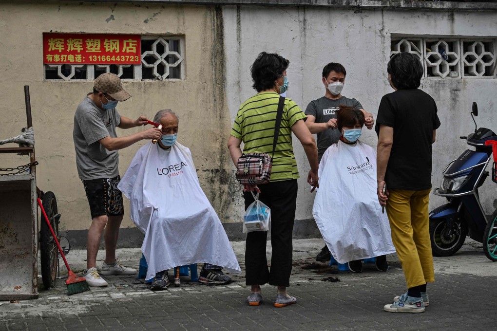 Residents received their haircuts out in the open on a street in the Jing’an district of Shanghai on June 3, 2022. Photo AFP