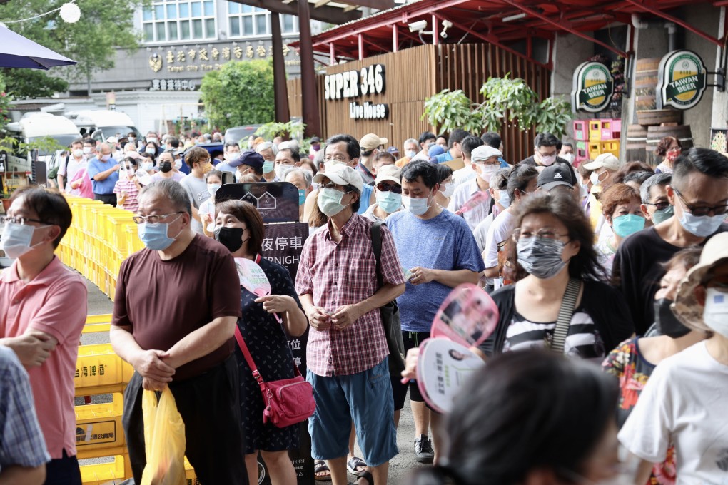 Residents queue for free rapid screening reagents, masks, toilet paper and other epidemic prevention supplies in Taipei on Friday. Photo: CNA