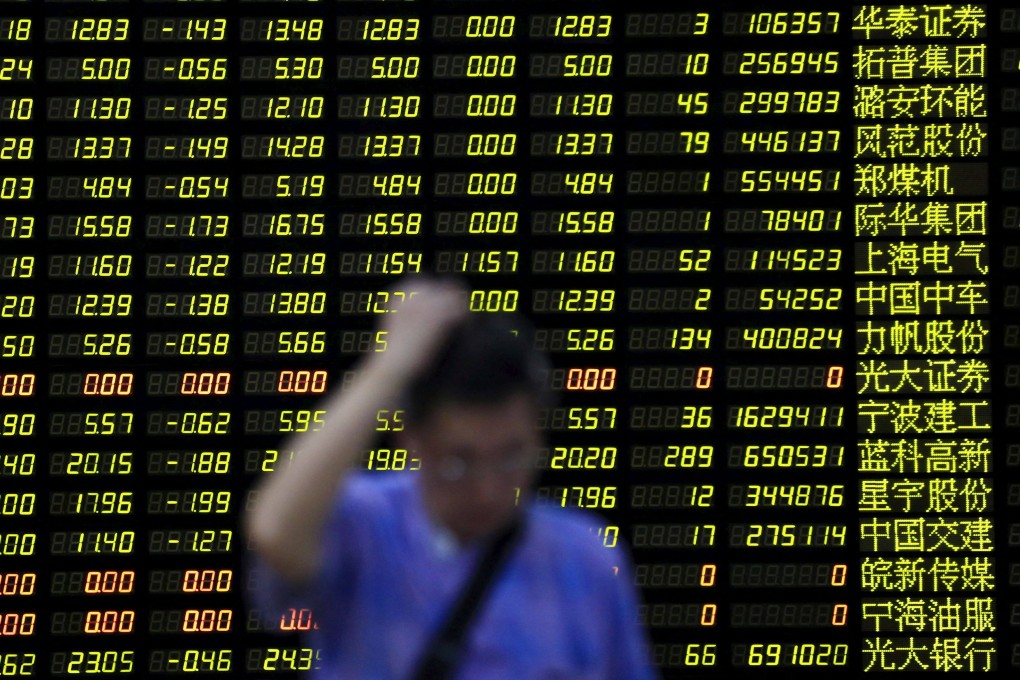 An investor stands in front of an electronic board showing stock information at a brokerage house in Shanghai. Photo: Reuters