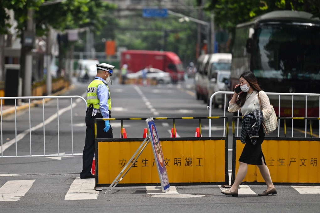 An officer stands at the entrance to a blocked street in a neighbourhood still under a Covid-19 lockdown in Shanghai on Thursday. Photo: AFP