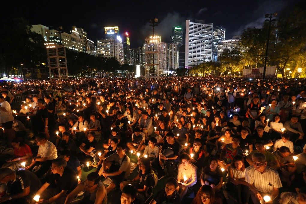 People hold up their candles during the June 4th Candle Light Vigil at Victoria Park in Causeway Bay. Photo: Dickson Lee