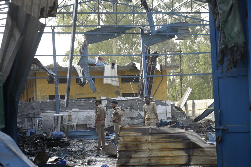 Policemen inspect the site of a fire that erupted in a chemical factory in northern India on Saturday. Photo: AP