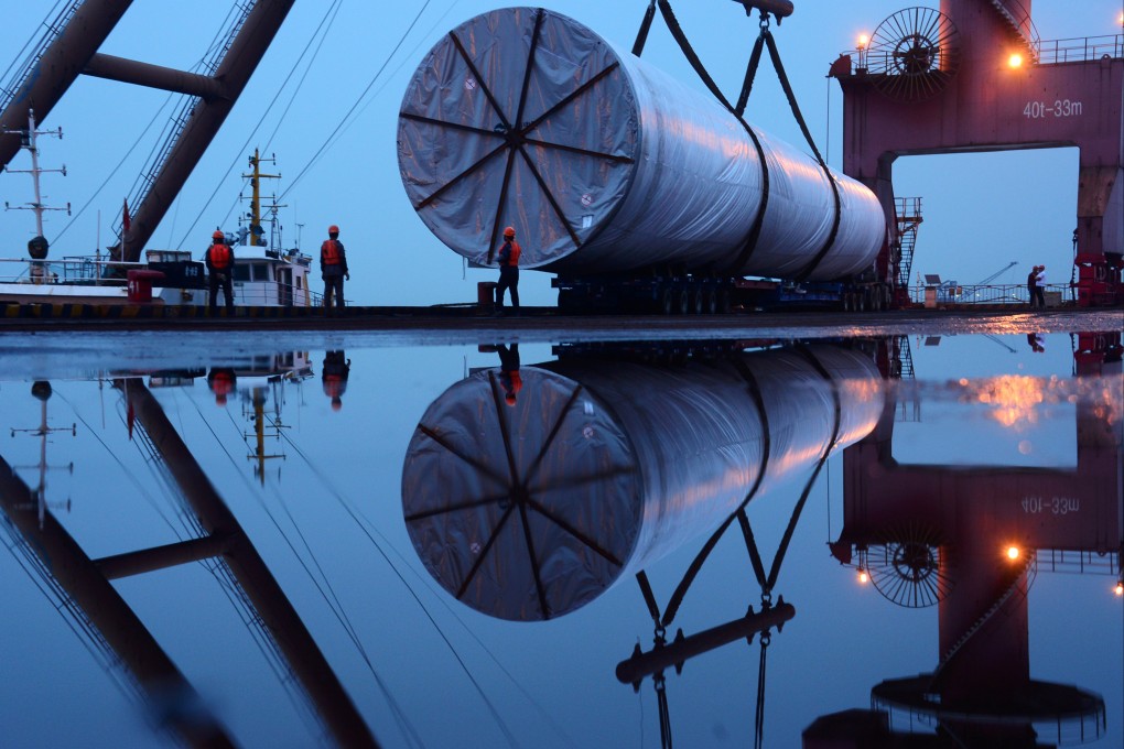 Workers are seen near a crane lifting offshore wind energy equipment in Nanjing, Jiangsu province, China, April 23, 2019. Photo: Reuters
