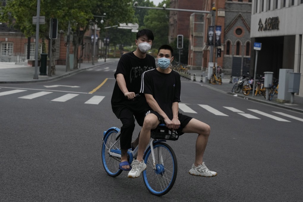 Residents in Shanghai share a bike as they ride on an empty road on June 1. China’s leading financial and business hub is coming out of a two-month Covid-19 lockdown that has set back the national economy and largely confined millions of people to their homes. Photo: AP