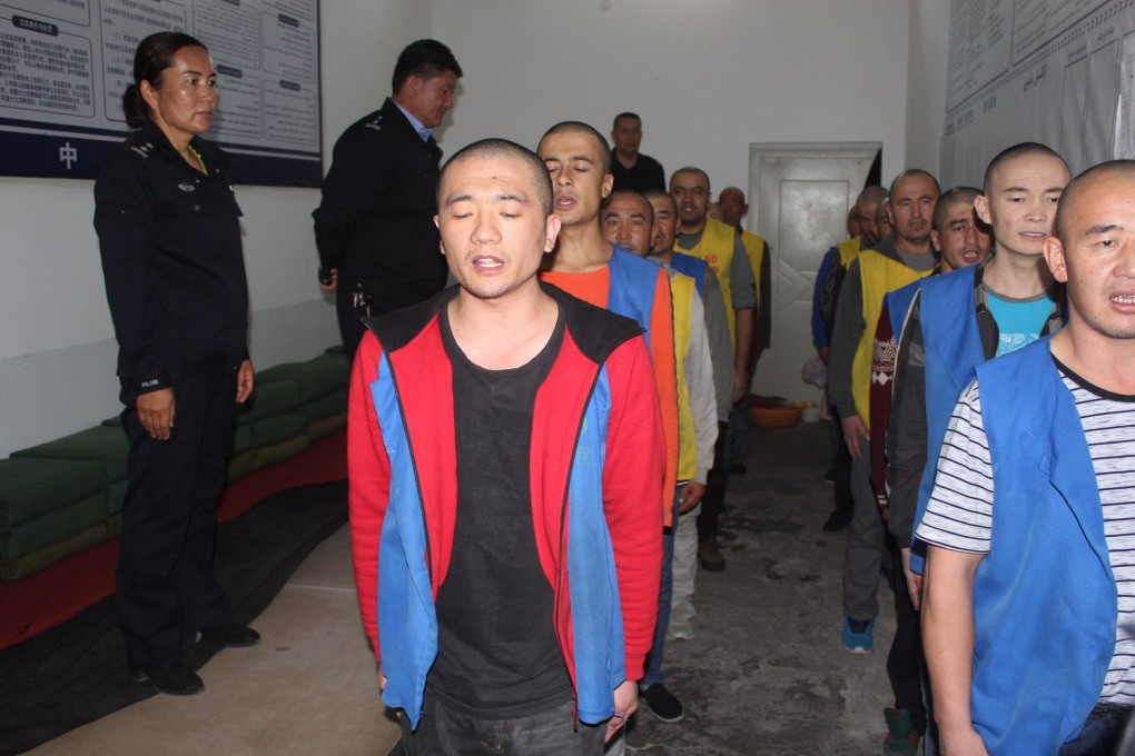 An undated image released by the Victims of Communism Memorial Foundation on May 24 shows detainees guarded by police as they recite or sing at the Tekes County Detention Centre in Xinjiang. Photo: AFP/Victims of Communism Memorial Foundation