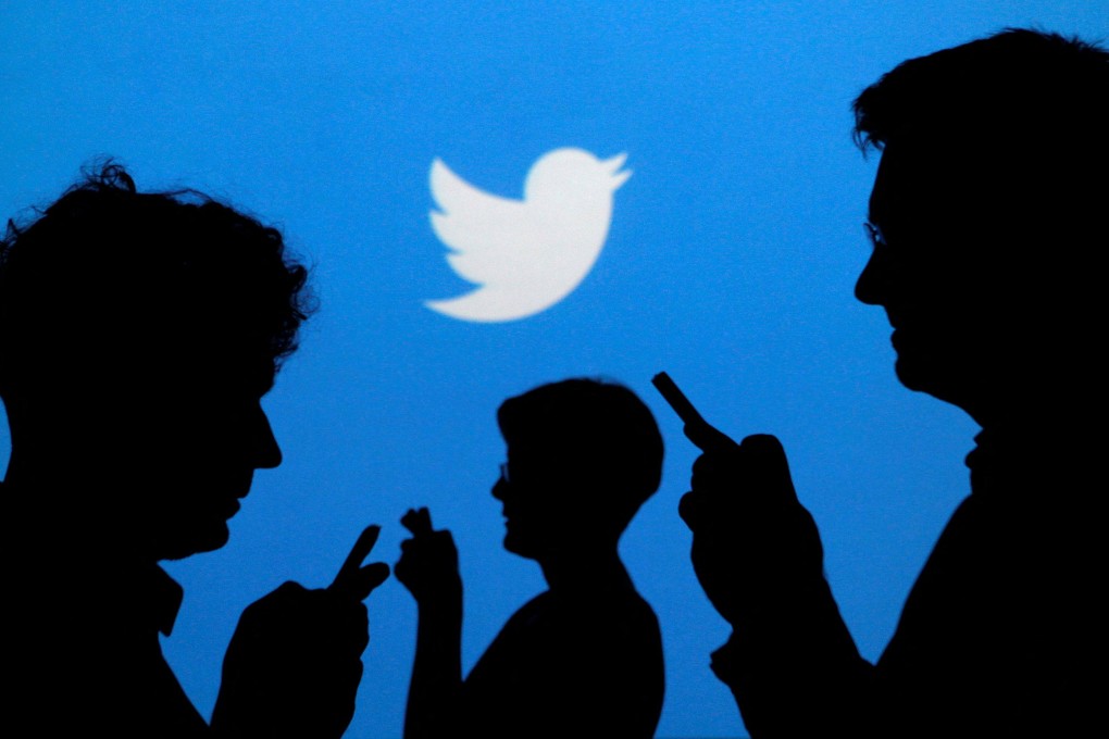 People holding mobile phones are silhouetted against a backdrop projected with the Twitter logo in this illustration picture taken in Warsaw on September 27, 2013. Photo: Reuters