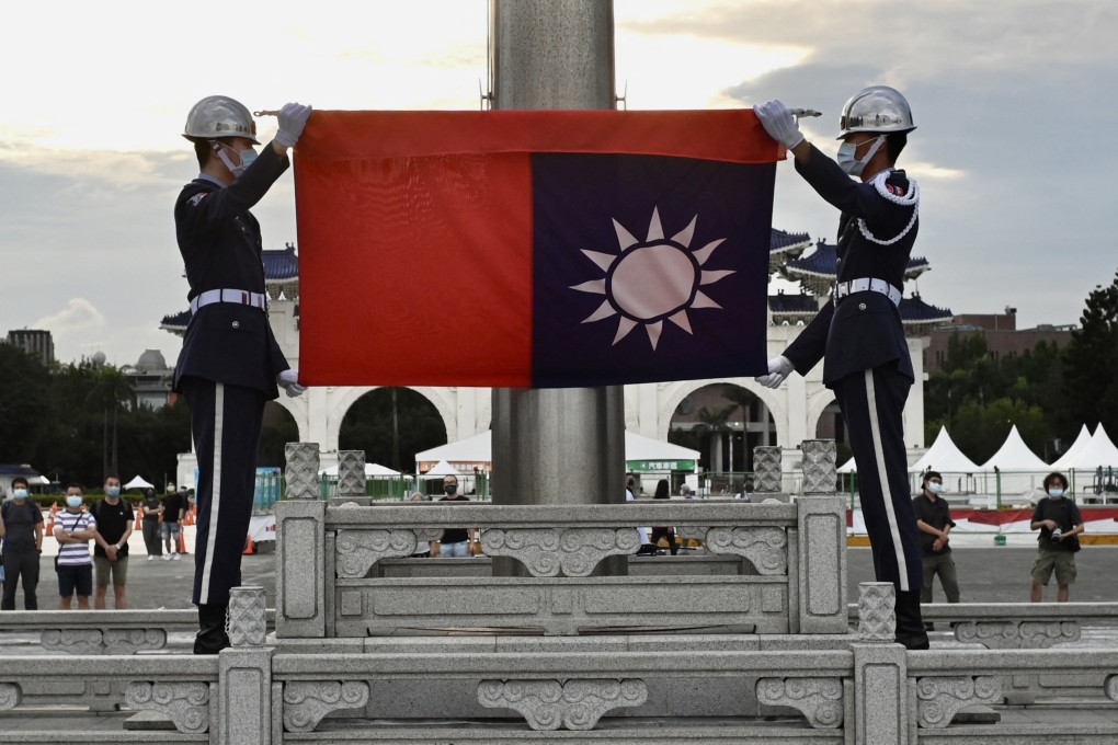 Honour guards fold the Taiwan flag during a ceremony in Taipei. Beijing has ramped up pressure on the island in recent years. Photo: AFP