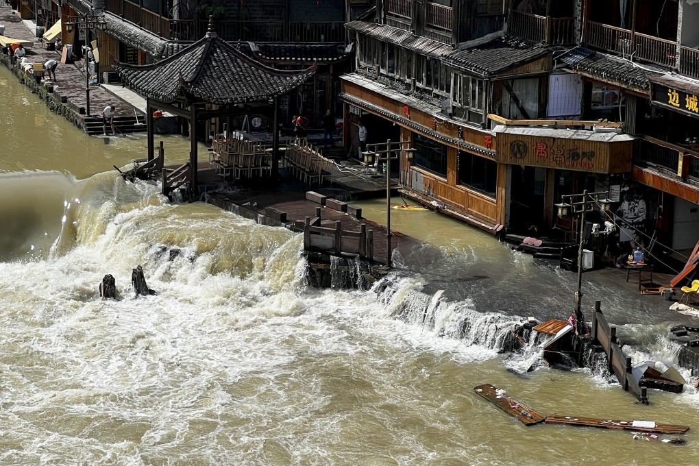 Flood waters sweep through the ancient town of Feng Huang in central China’s Hunan province. Photo: AP
