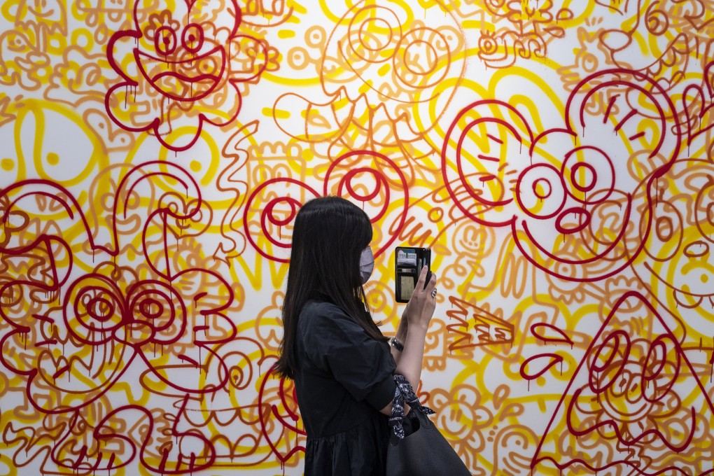 A visitor takes a picture of a painting at Art Basel Hong Kong 2022. New international art fairs in the city over the past 15 years have brought a higher level of cosmopolitanism and sophistication to the industry. Photo: Getty Images