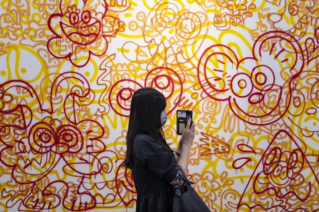 A visitor takes a picture of a painting at Art Basel Hong Kong 2022. New international art fairs in the city over the past 15 years have brought a higher level of cosmopolitanism and sophistication to the industry. Photo: Getty Images