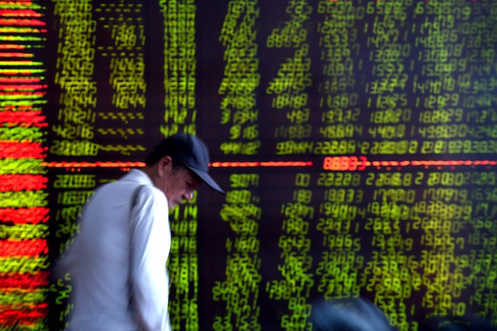 An investor looks through stock information at a trading hall in a securities firm in Shenyang in northeastern Liaoning province. Photo: Xinhua